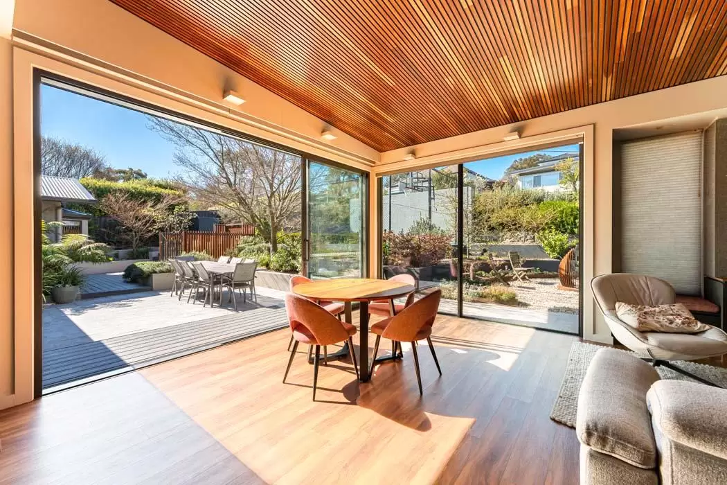 Indoor outdoor living space with a timber ceiling opening onto the patio and garden